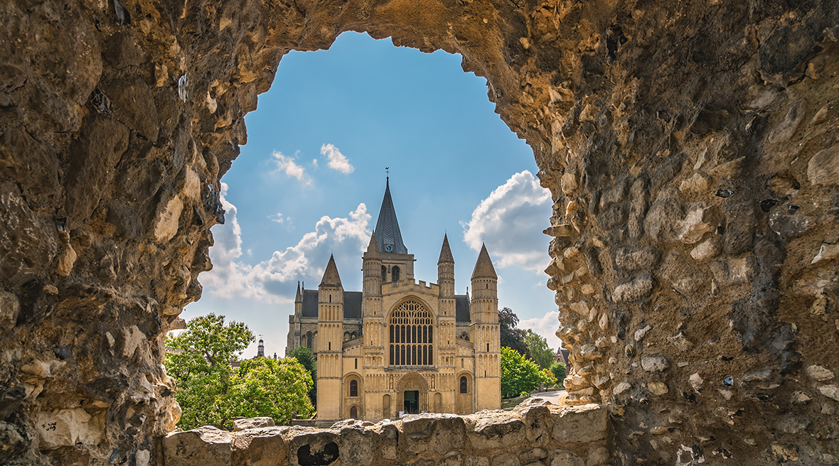 De kathedraal van Rochester gezien van onder een gewelf van grove stenen